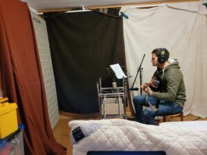 Im improvisierten Tonstudio wird Dani mit der Gitarre aufgenommen.